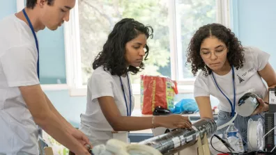 Trois jeunes membres assemblent une fusée expérimentale