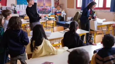 Un ingénieur parle de l'espace à des élèves dans une salle de classe