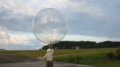 Personne tenant un ballon-sonde transparent