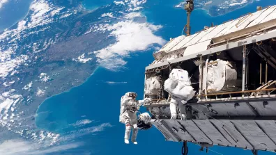 Photo réelle de deux astronautes pendant une sortie extravéhiculaire à l'extérieur de l'ISS