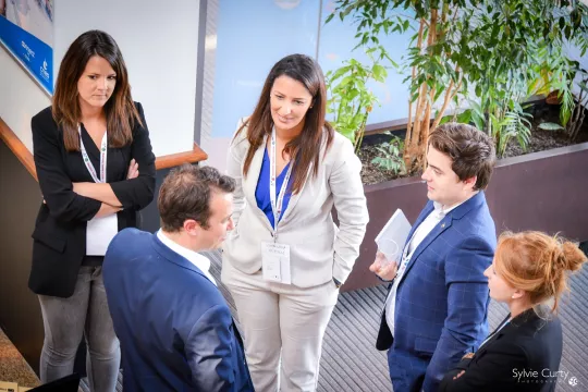 Groupe de cinq personnes, hommes et femmes, discutant ensemble